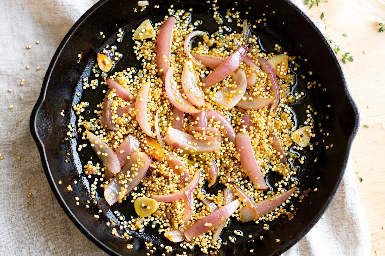 Quinoa toasting in the skillet with softened aromatics.