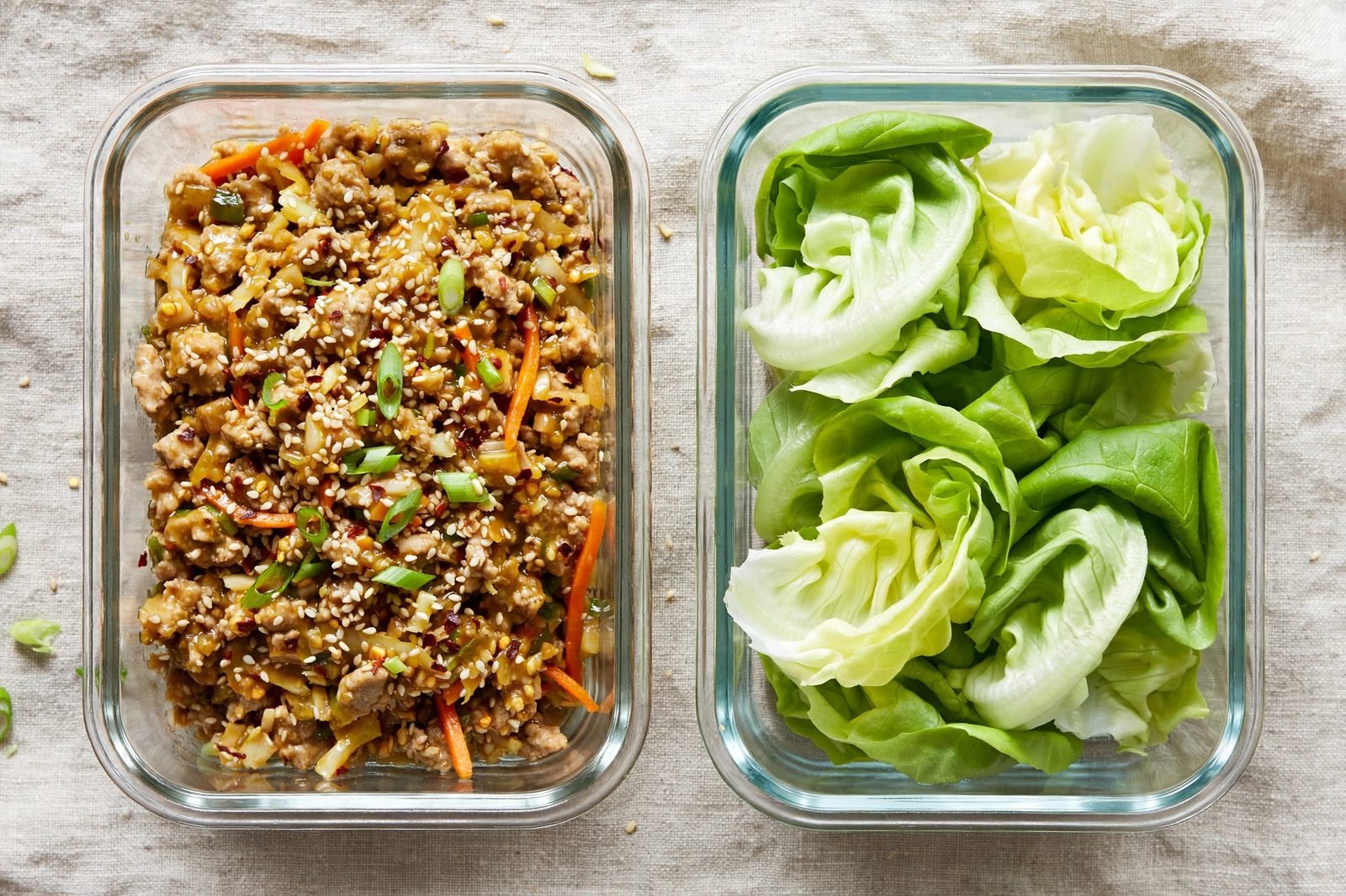 Meal-prep containers with sesame ginger turkey filling and lettuce leaves packed separately.